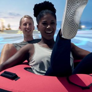 Couple In Tandem Tubes On Snowy Slopes